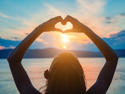 Woman with heart shaped sign enjoying ocean tropical time.
