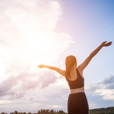 Happy smiling athletic woman with arms outstretched