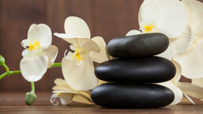 Stack of pebble stones with flowers on a table